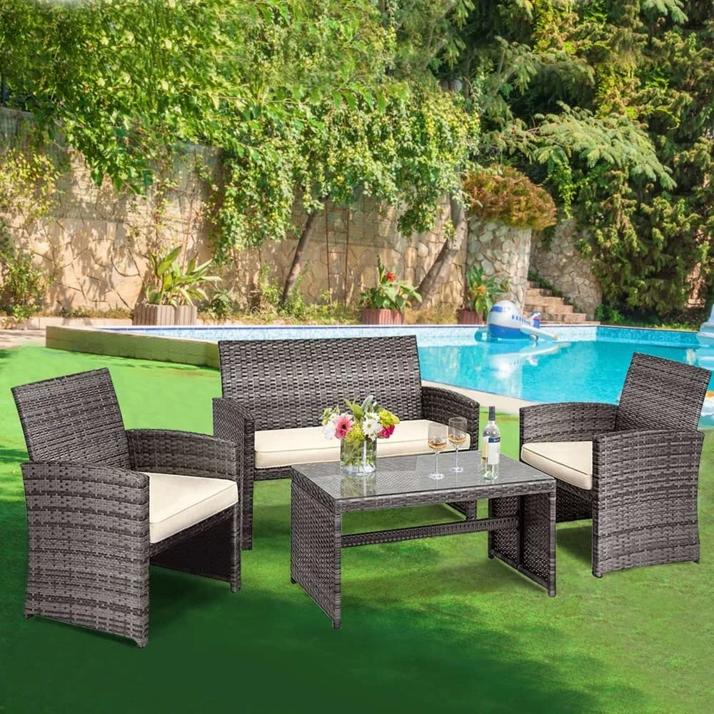 Set of 4-piece rattan garden furniture with table and padded chairs