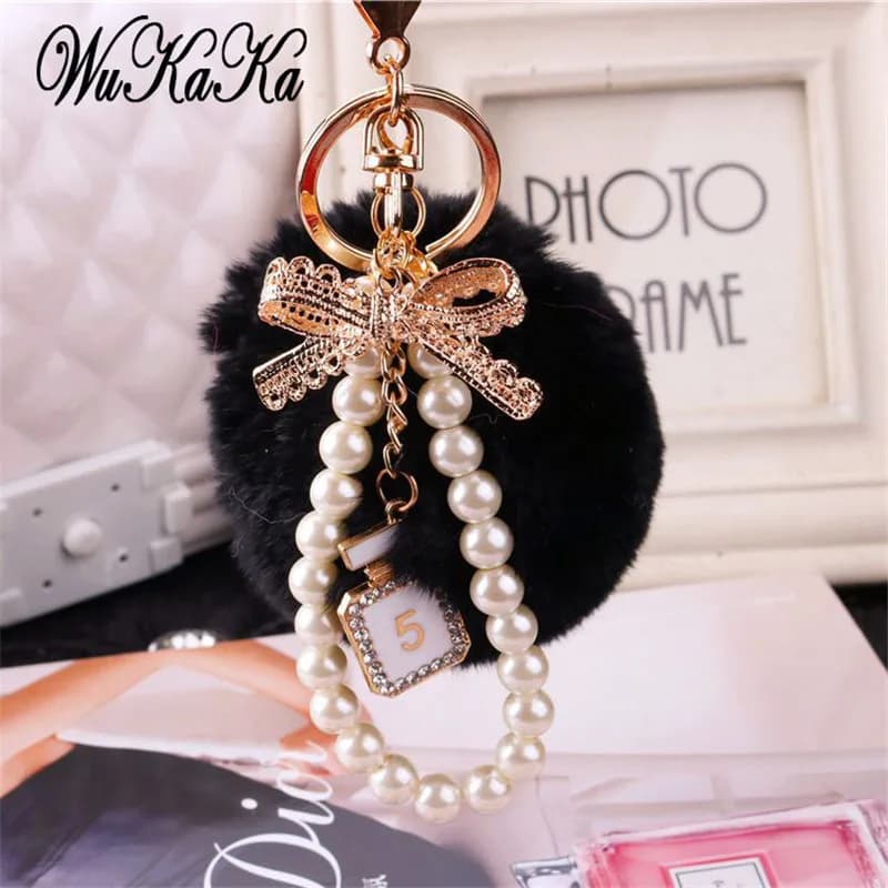 2026 moda catena di perle bottiglia di cristallo arco pompon portachiavi auto borsa da donna portachiavi anello soffici soffio palla portachiavi gioielli