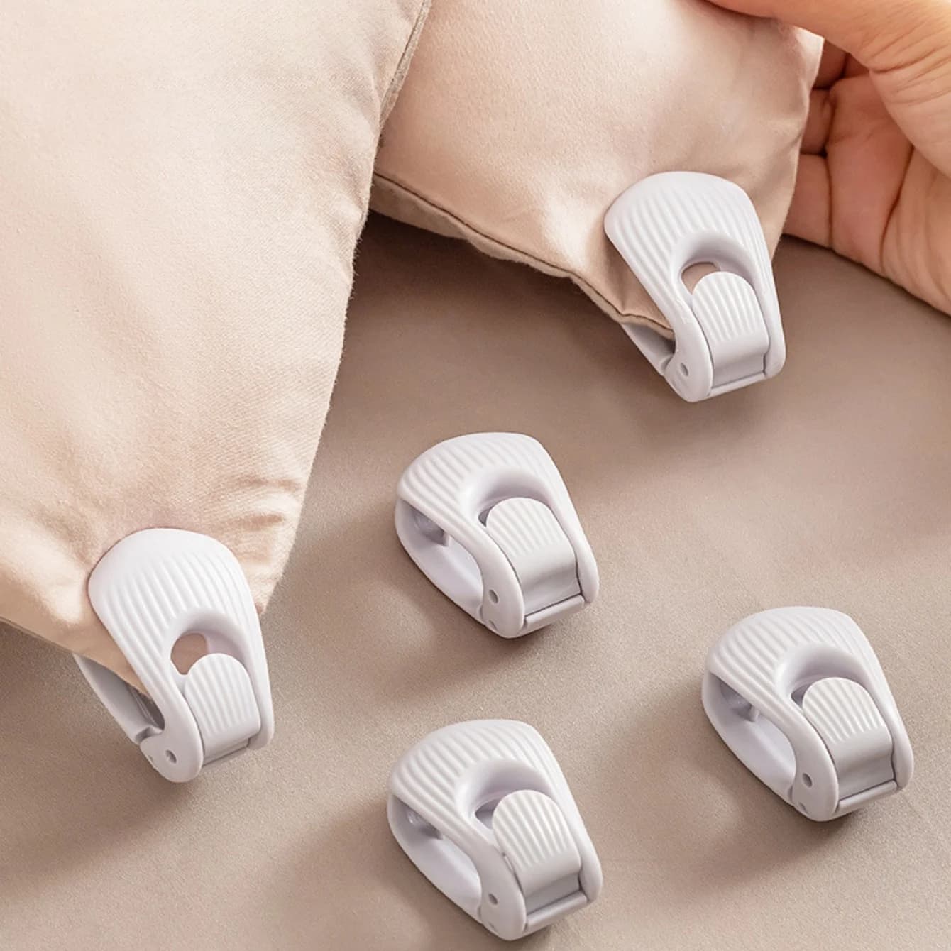 Non-slip fixing device for home bed linen, secure design without needles, easy to use to fix duvet covers and sheets. Prevents deviation.