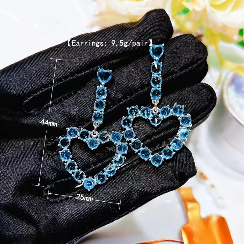 Orecchini da donna con cuore in paillettes blu e pietre incastonate a contrasto. Graziosi orecchini a forma di cuore rosa con diamanti rosa, dallo stile unico, leggeri e lussuosi.