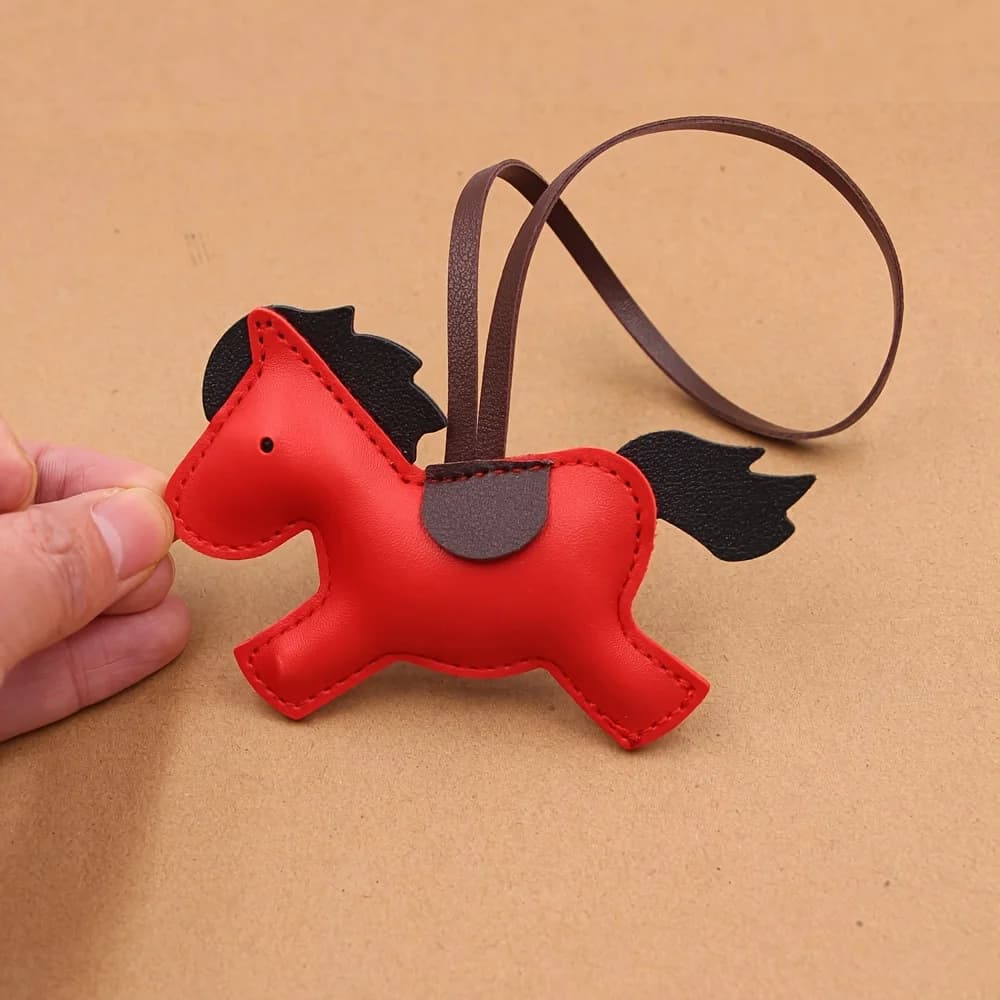Marchio alla moda di Capodanno Abbigliamento in pelle di Capodanno, bagagli, accessori portachiavi, materiali coordinati, simpatico ciondolo a forma di piccolo cavallo.