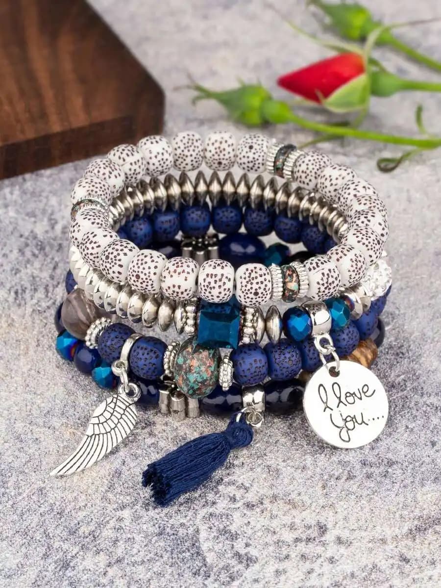 Set di 4 braccialetti elastici Boho con perline di lava blu macchiate di bianco, ciondolo a forma di ala argentata, nappa e scritta a mano 'I Love'