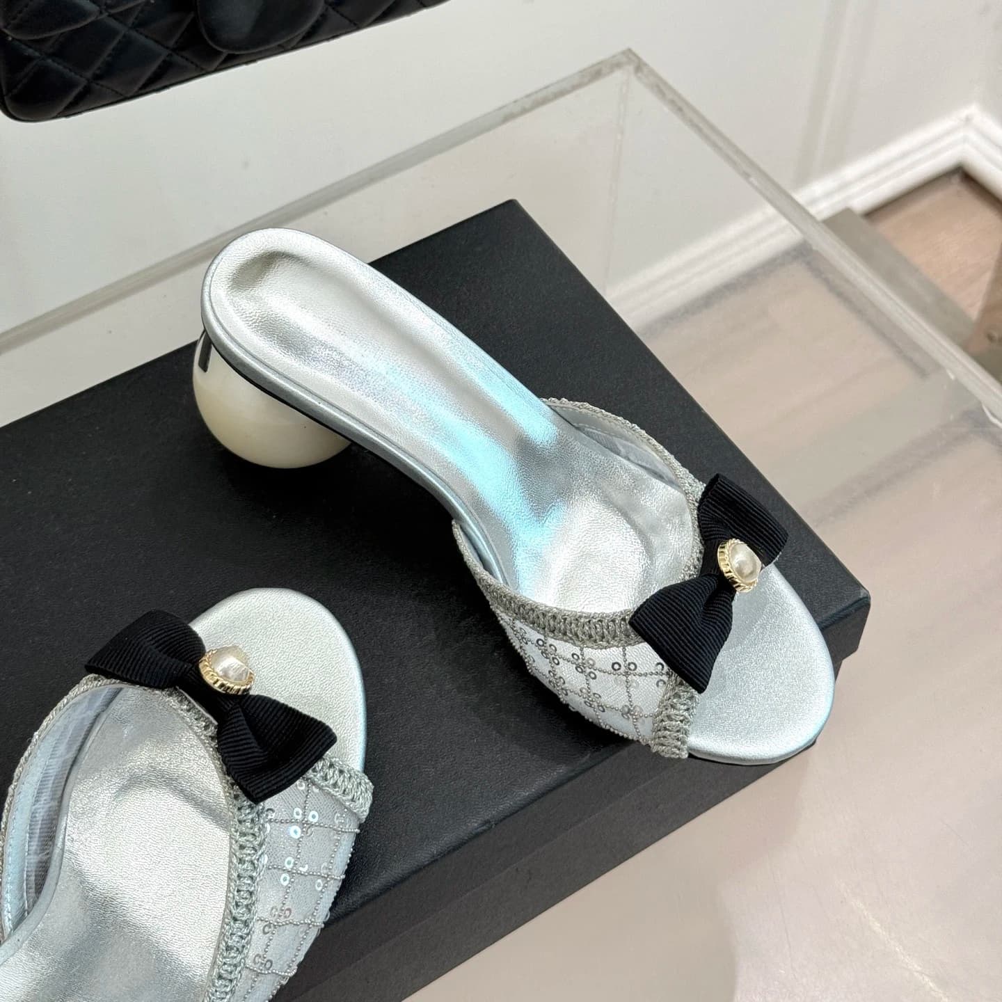 Mules da donna con fiocco, decorazioni in cristallo e tacco con perle, tomaia in paillettes e pizzo, che emanano lusso ed eleganza.