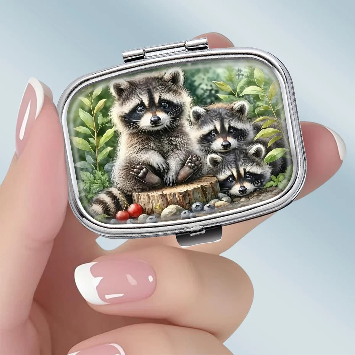 This Portable Square Metal Pill Box Features a Cute Forest-Themed Design with an Image of a Raccoon Family, Has Two Compartments, and Is an Ideal Choice for Elegantly Storing Medicines or Health Supplements. It Is Also Very Suitable for Organizing Vitamins and Storing Small Items.