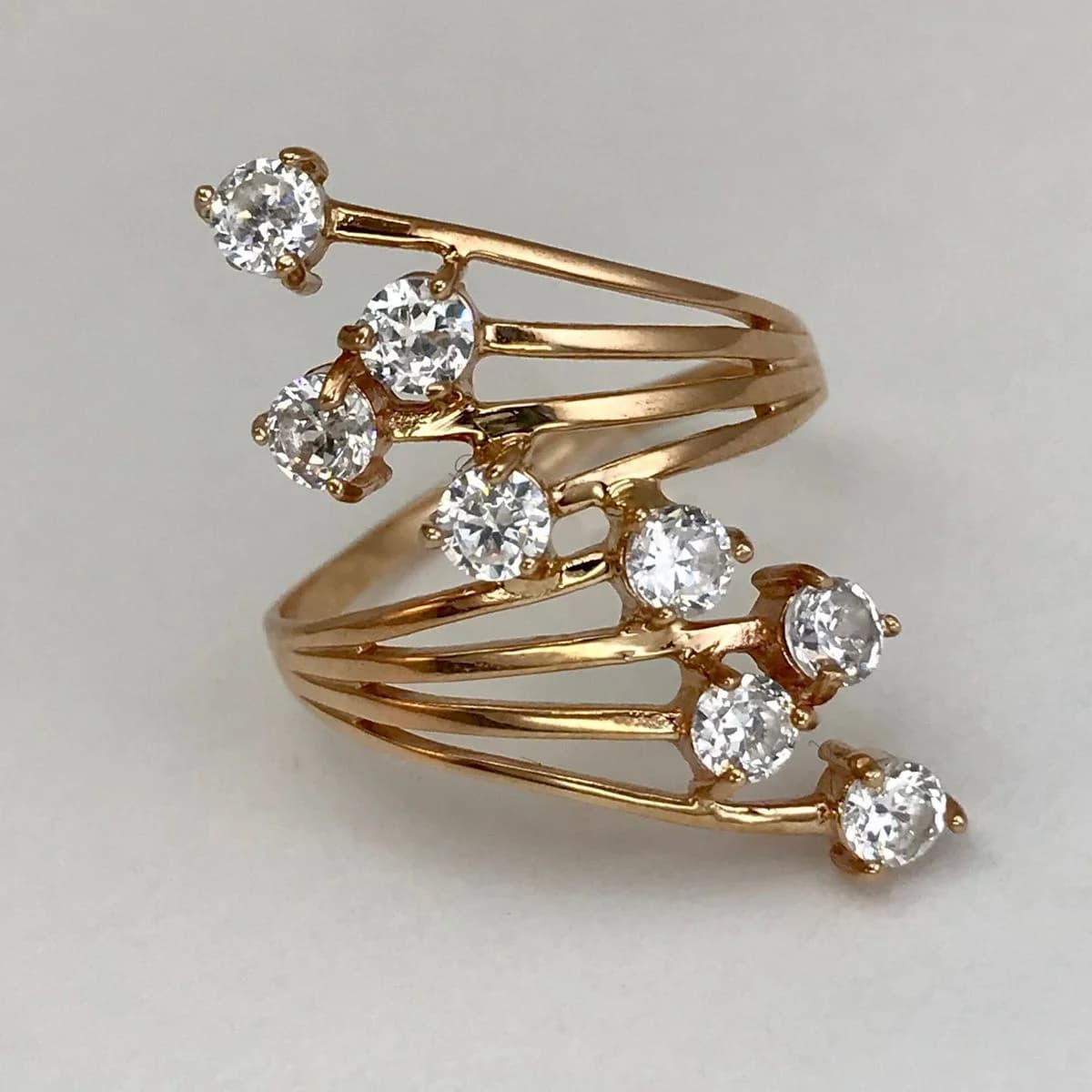 Elegant multi-layered ring with artificial gemstones intricately set around the body. Women's ring suitable for casual dates.