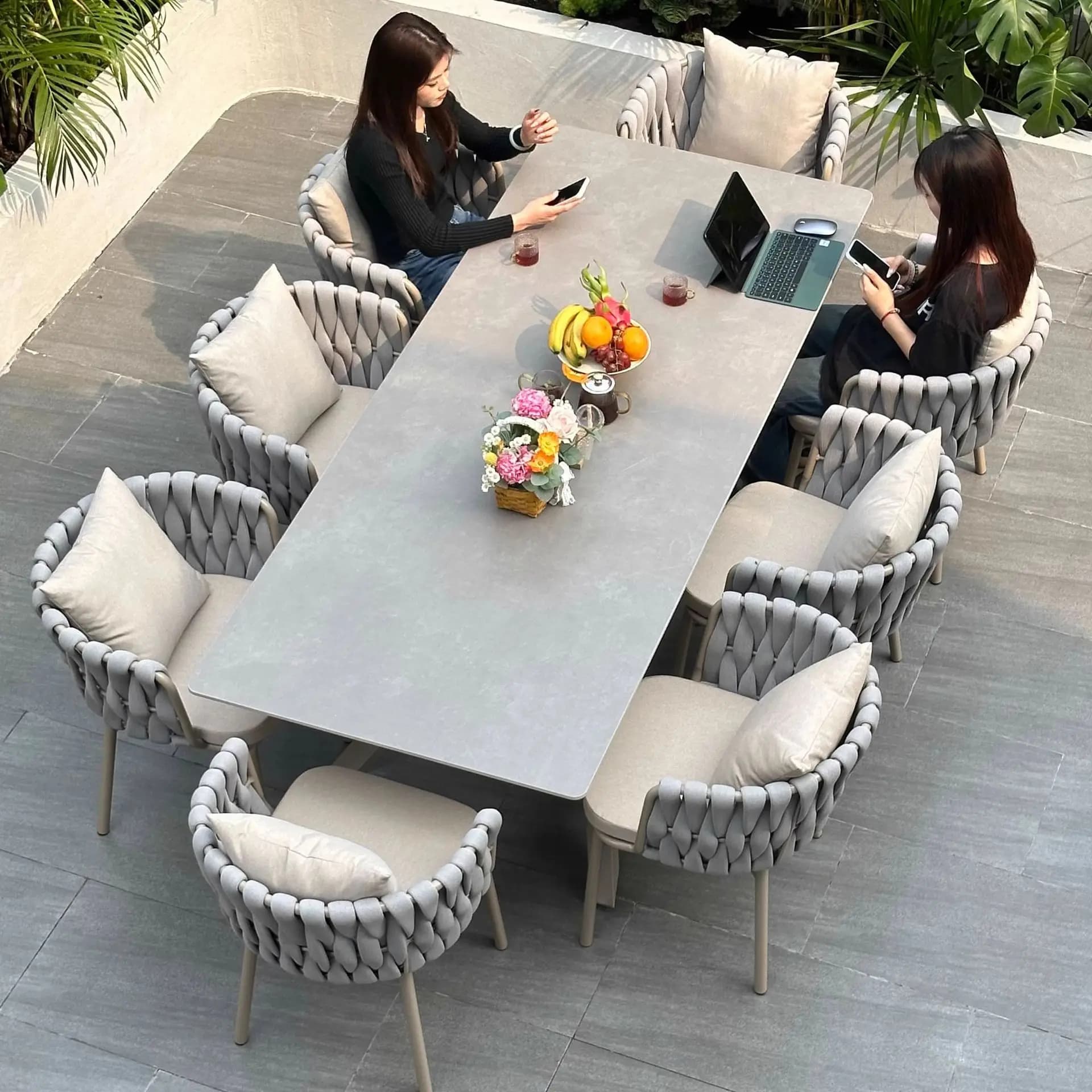 Mobili da esterno di alta gamma in rattan impermeabile e resistente ai raggi solari per cortili, giardini e balconi, con tavolo da pranzo in lastra di roccia.