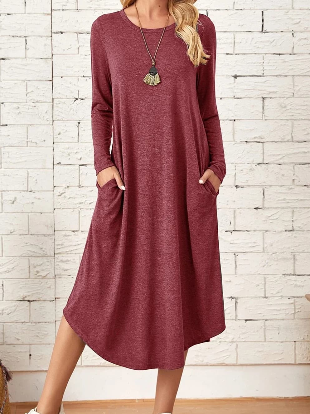 Women's knitted dress with diagonal pockets and curved hem