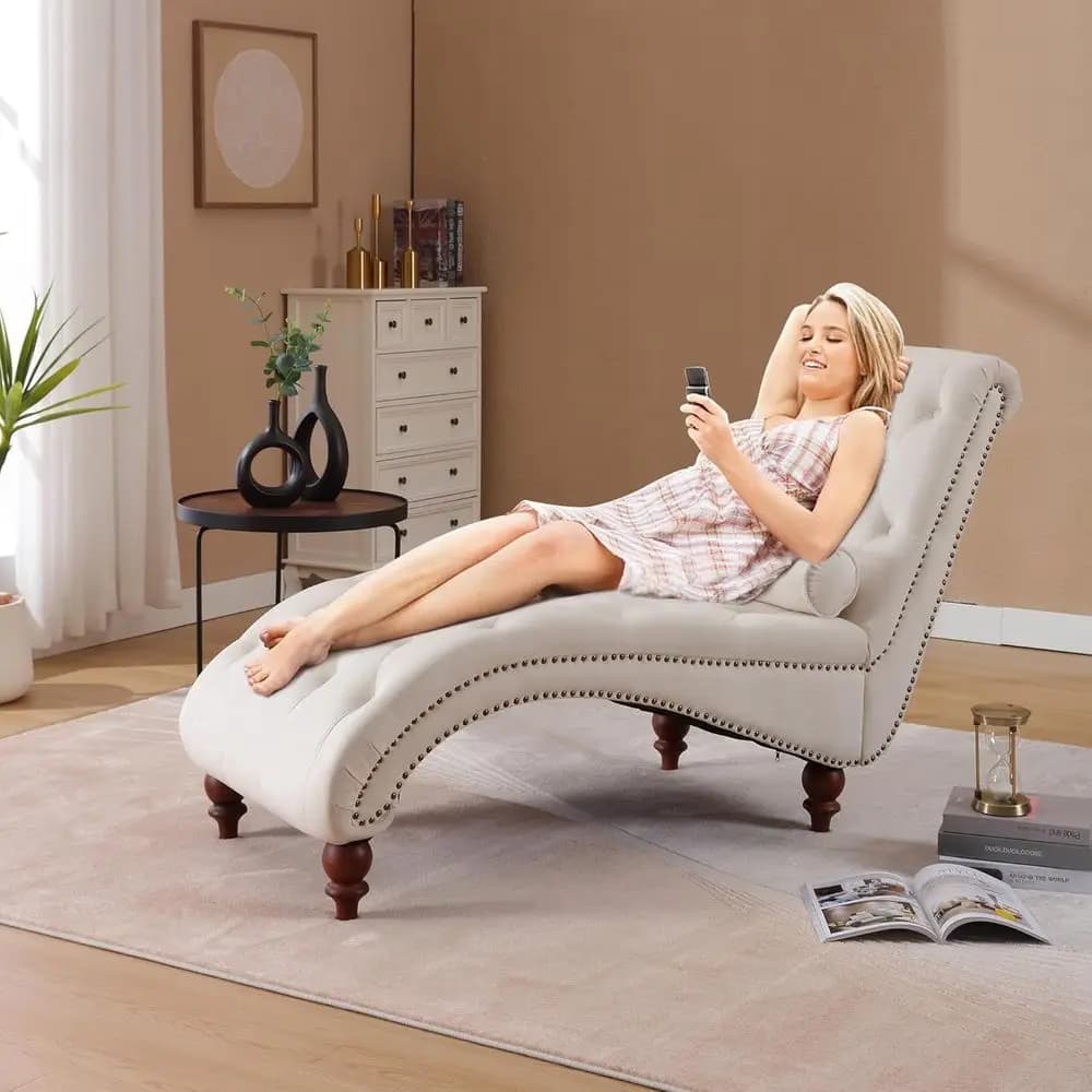 Chaise longue in velluto beige con finiture a borchie, braccioli trapuntati, cuscino lombare e gambe in acrilico per soggiorno o camera da letto