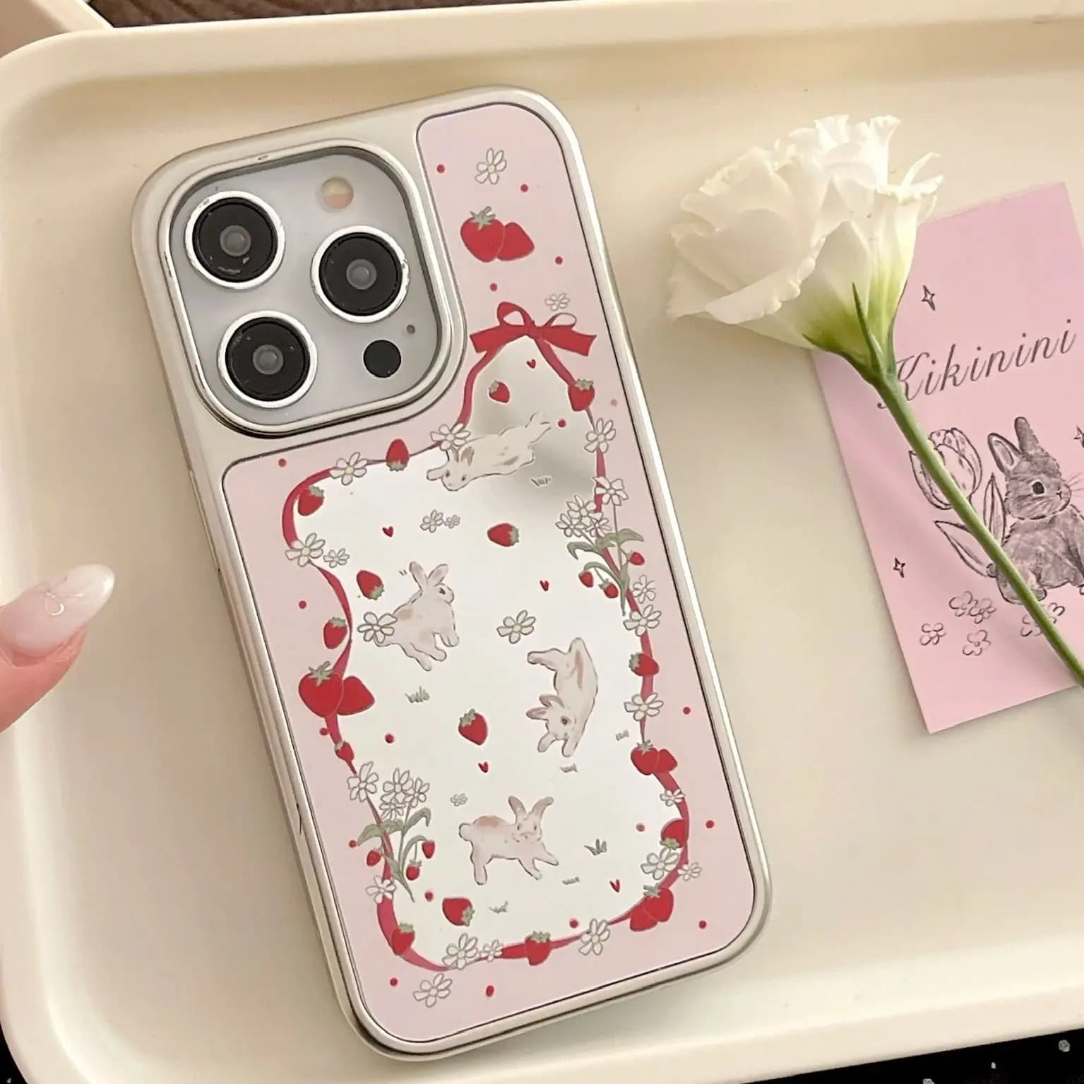 Custodia con bordo in nastro di superficie a specchio con fiocco in nastro di seta con fiocco a forma di fiore rosa coniglio fragola per iPhone 13 14 15 16 Pro Max