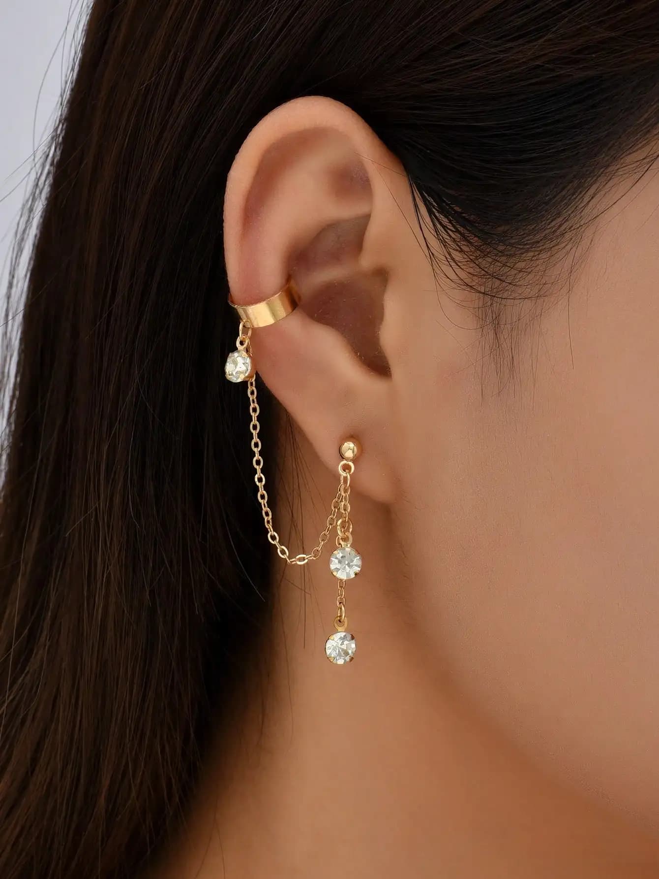 Set of gold colored clip and lobe earrings with crystal drops, hip hop style