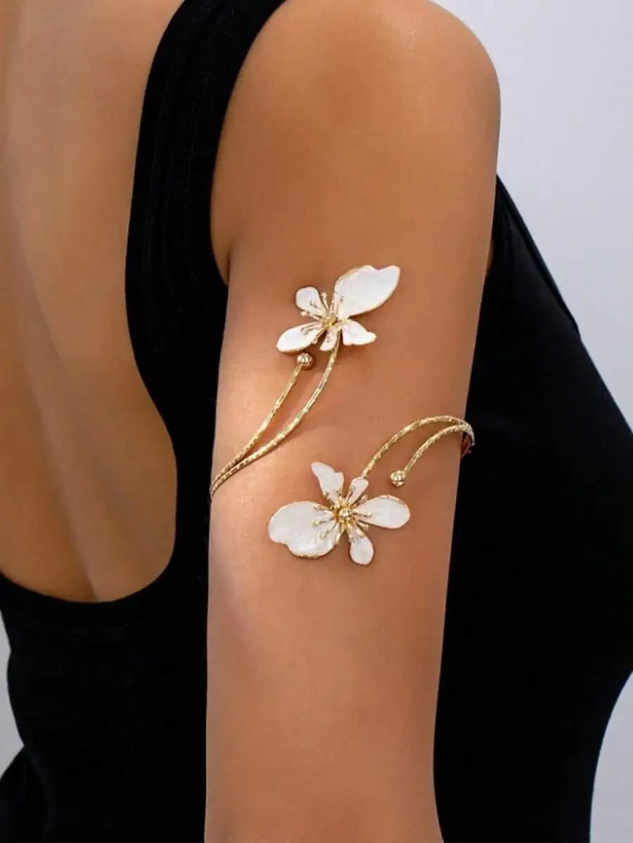 Elegante bracciale aperto color oro con motivo floreale bianco per uso quotidiano da donna