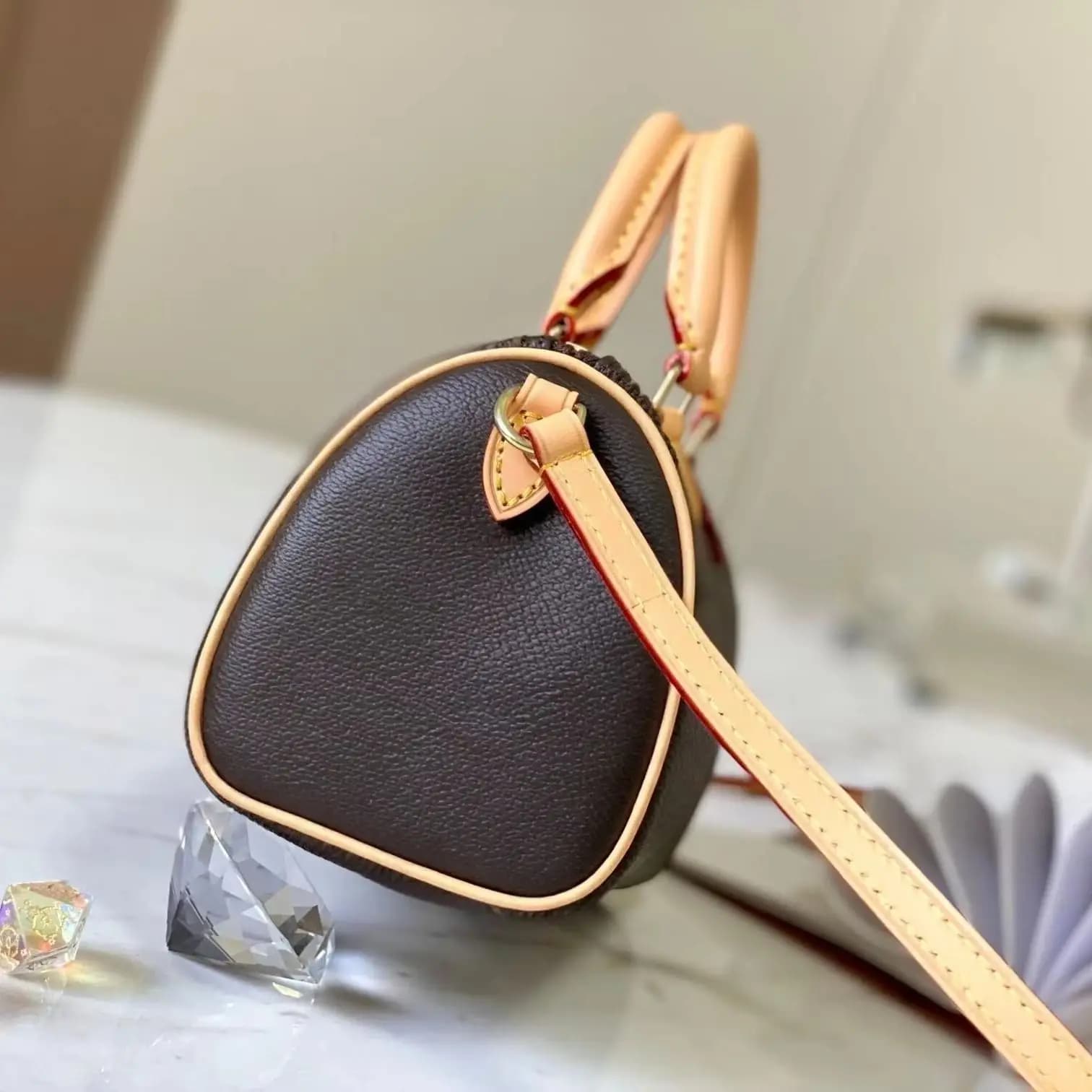Dark brown textured mini Boston bag, with natural leather handles, removable and adjustable crossbody strap, gold zipper closure, a vintage-style women's handbag that can be used both ways.