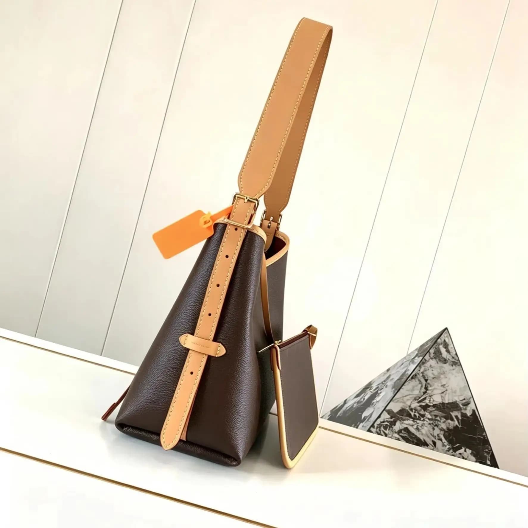 Deep brown smooth leather shoulder bag with leather trim, adjustable wide strap, and a matching mini zip pouch decoration.