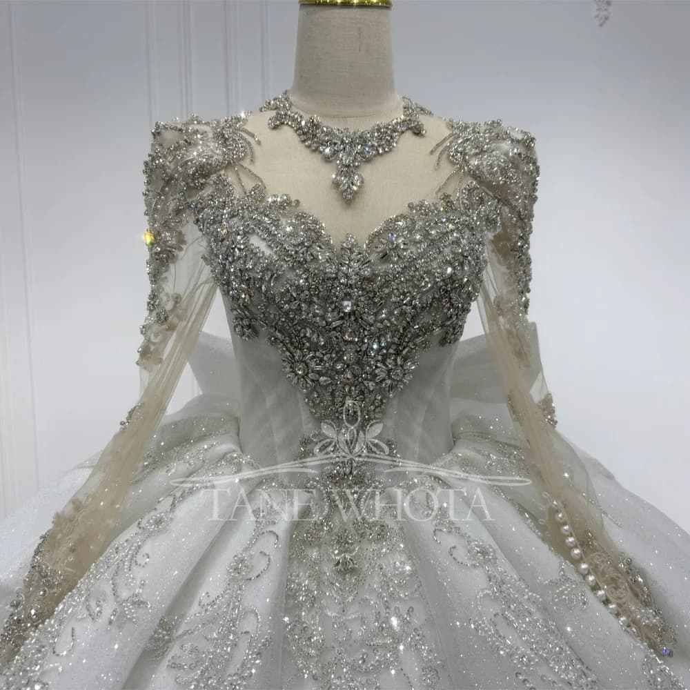 Abito da sposa di lusso con maniche lunghe, cristalli, paillettes, fiocco, schiena con apertura a goccia, scollo a O, allacciatura e gonna a ball gown per donna