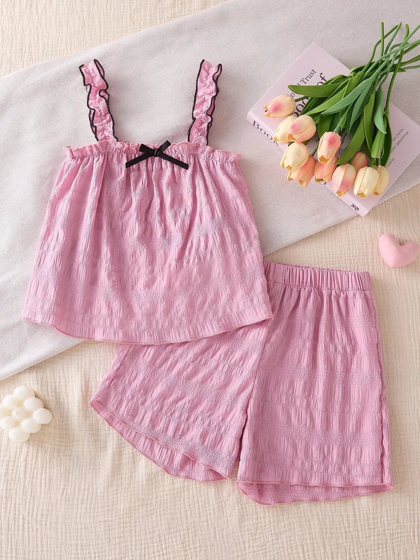 Collezione estiva di abbigliamento alla moda per ragazze, dolce e semplice completo rosa con fiocco, composto da canotta e pantaloncini per il tempo libero all'aperto.
