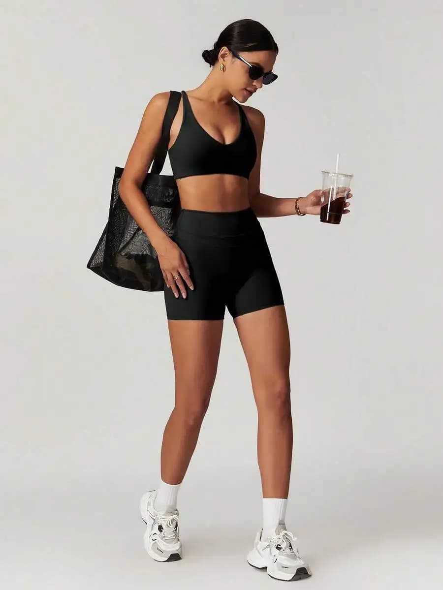 Set sportivo nero da donna con pantaloncini a vita alta e top reggiseno per yoga e fitness