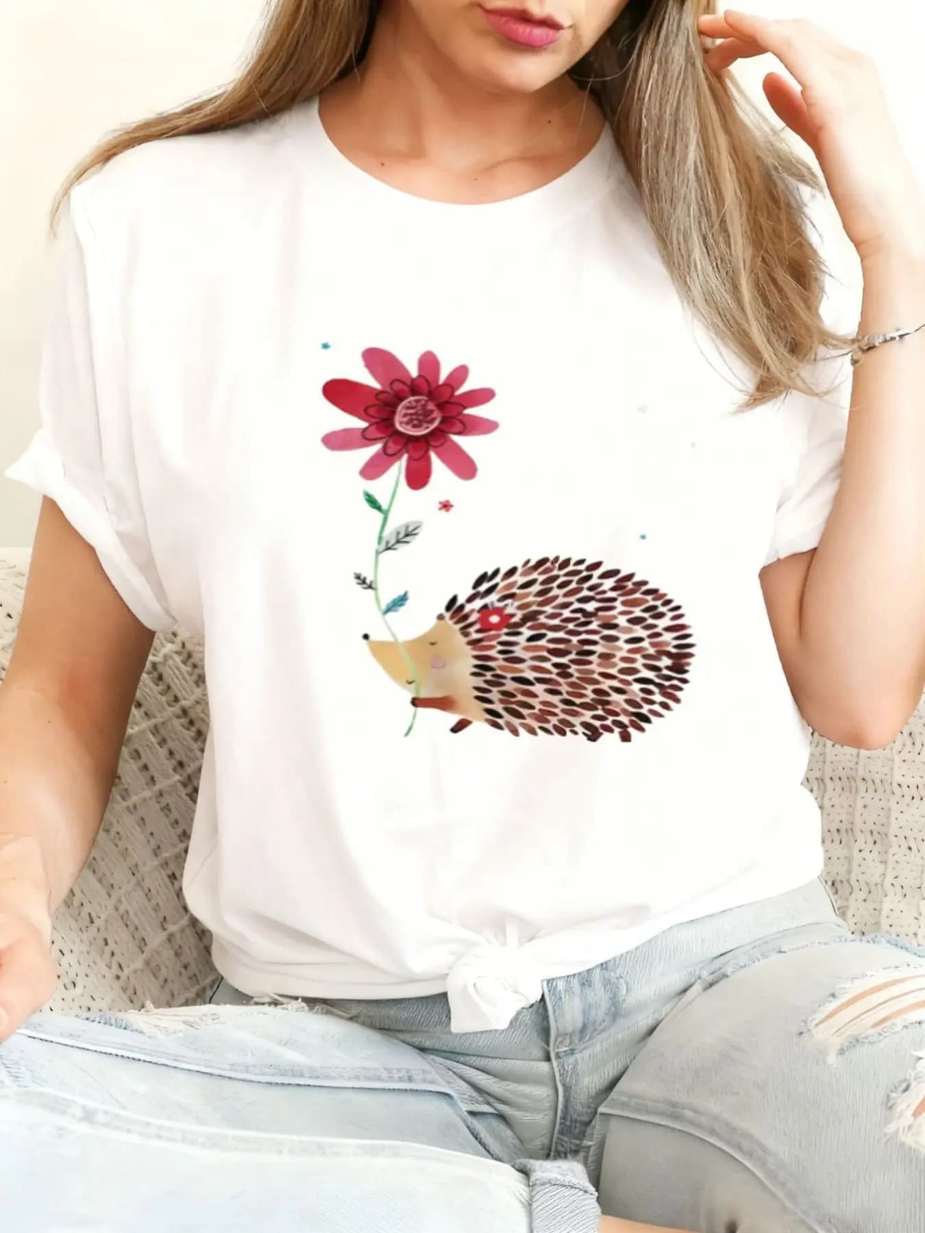 Easter and St. Patrick's Day Cute Hedgehog Holding Flowers T-Shirt, Black Crew Neck Casual Short-Sleeve T-Shirt, Decorated with Pink Flowers and Green Stems, Model with Light Brown Fur, Paired with Light Blue Ripped Jeans, Ideal Gift for Spring Festivals