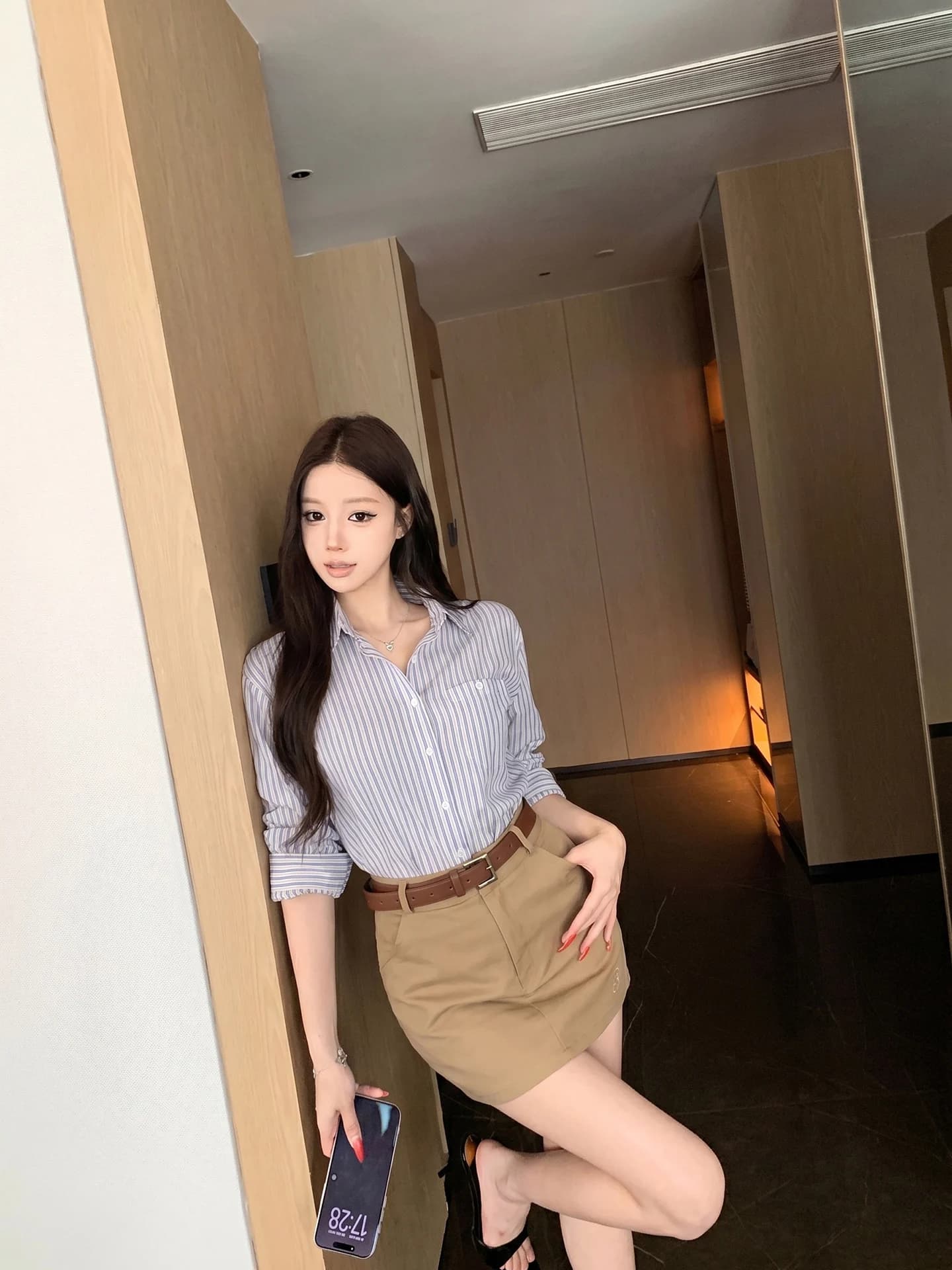 Completo da donna due pezzi stile pendolare: top a maniche lunghe con colletto a risvolto a righe blu e bianche e gonna corta a vita alta color kaki per l'estate
