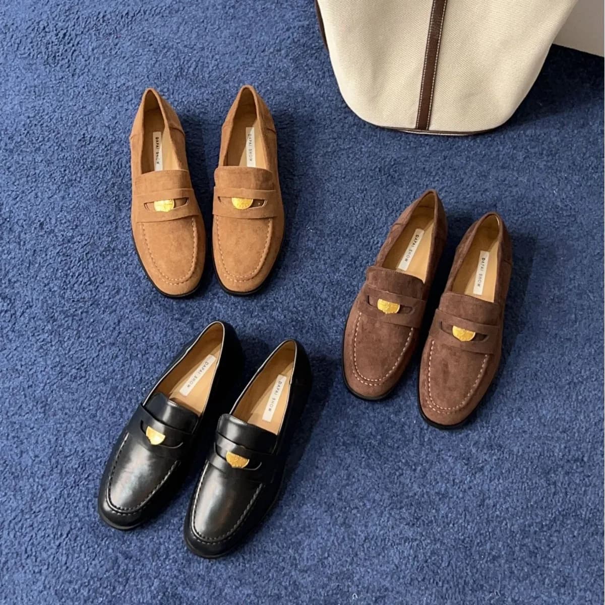 Mocassino classico con stemma in pelle nera | Lussuosa parte superiore in pelle scamosciata tinta unita | Dettaglio del fascino della moneta della firma | Suola in gomma resistente