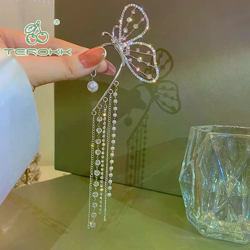 Orecchino a clip con farfalla di cristallo, perla e nappine lunghe