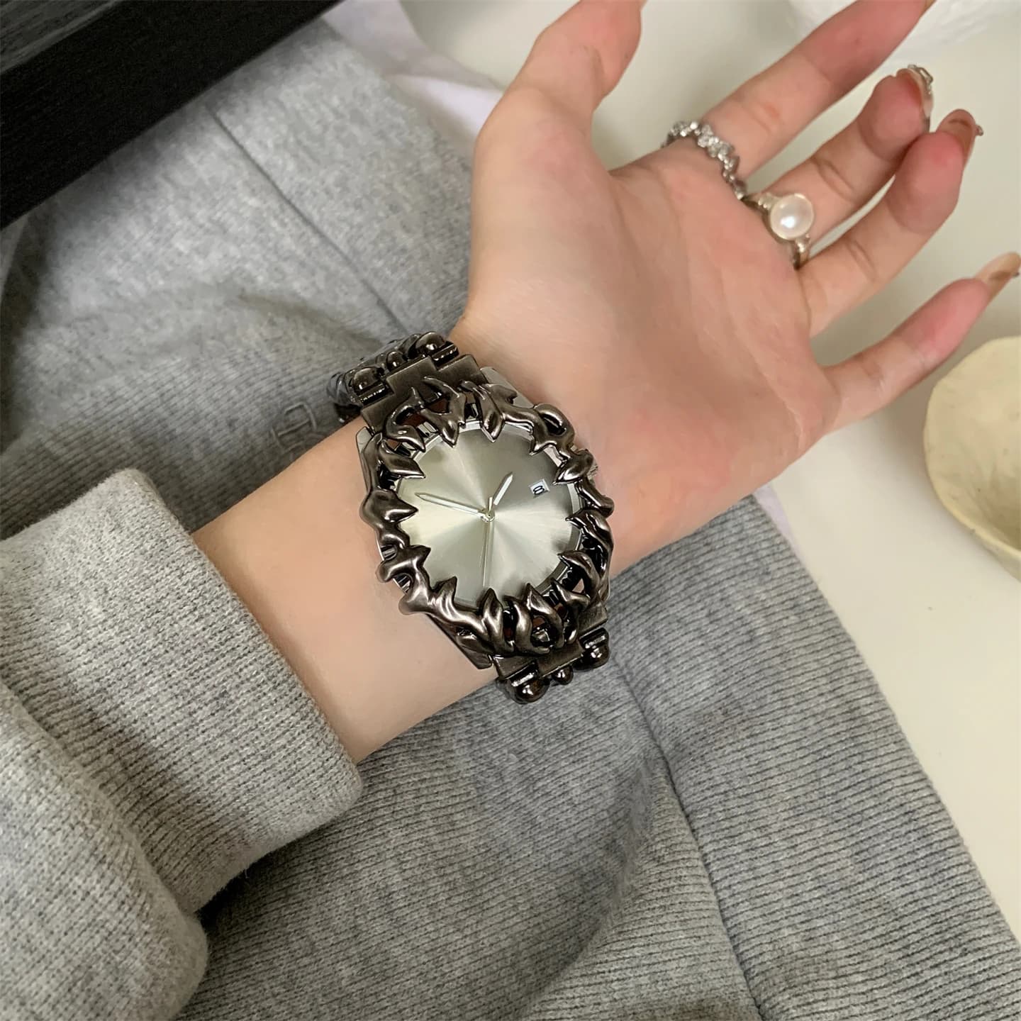 Piccola nuova tendenza creativa degli antichi artigli dalla forma speciale per uomini e donne guardano l'orologio con cinturino in acciaio goffrato dal design.