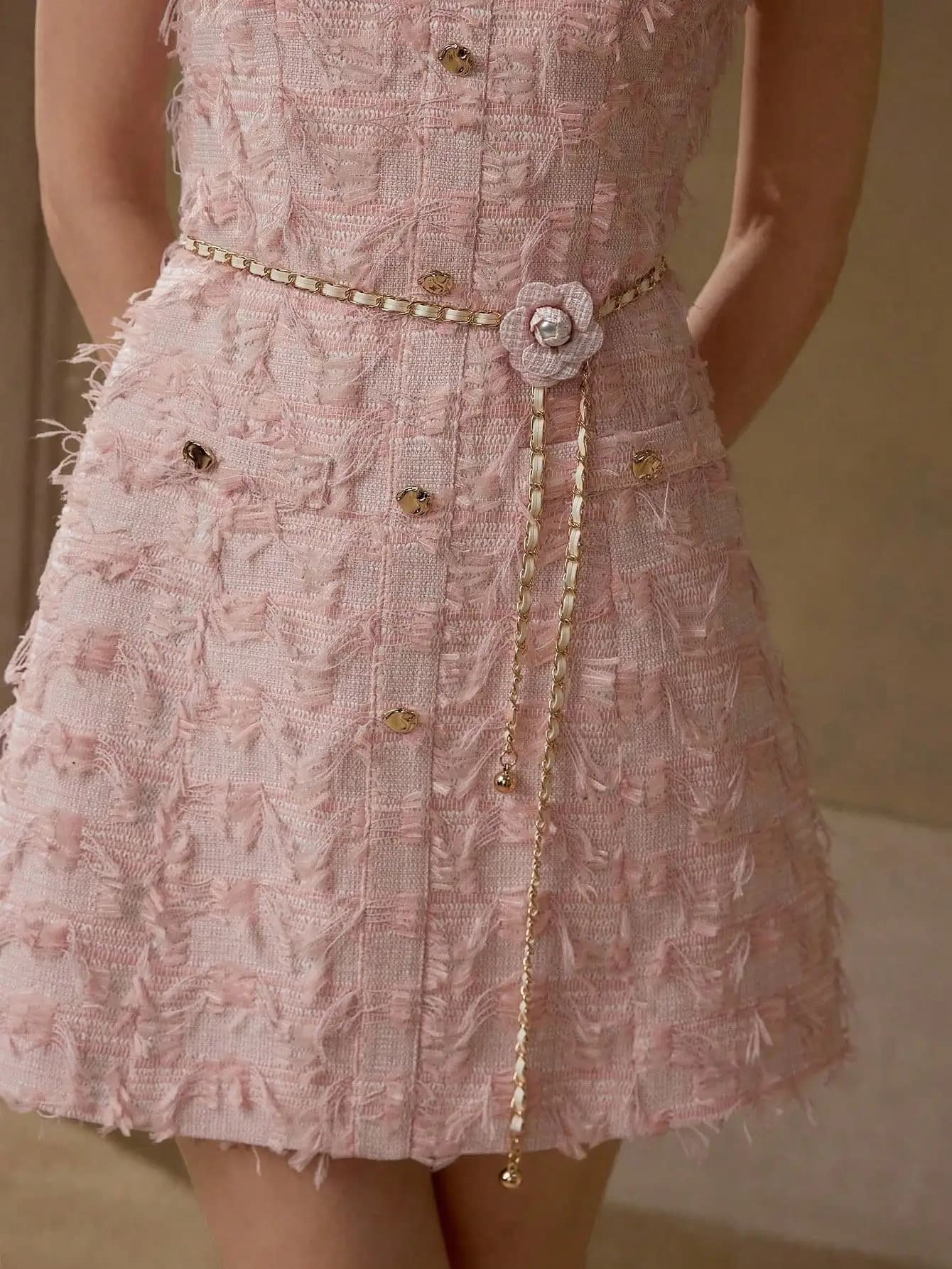 Mini abito rosa in tweed senza maniche con bottoni e cintura a catena
