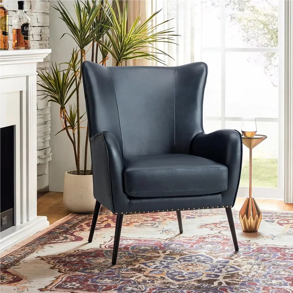 Poltrona con accenti in similpelle e cuscino rimovibile, comoda poltrona imbottita con gambe in metallo nero e finiture con borchie, modello Wingback V