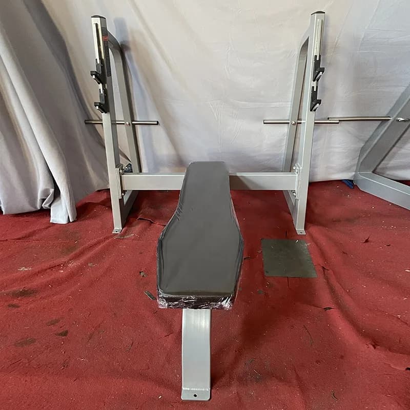 Commercial fitness equipment for muscle building, flat bench for weight lifting with plates, for gym or club.