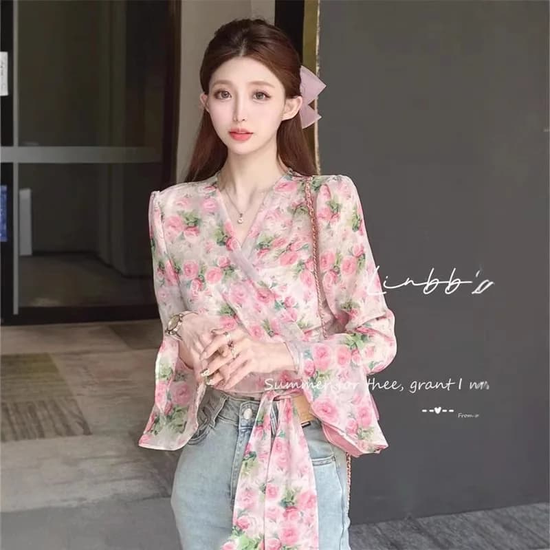 Camicia floreale con fasciatura irregolare con fiocco stampato alla moda Abbigliamento femminile 2025 Estate Nuove magliette casual Camicetta con maniche svasate