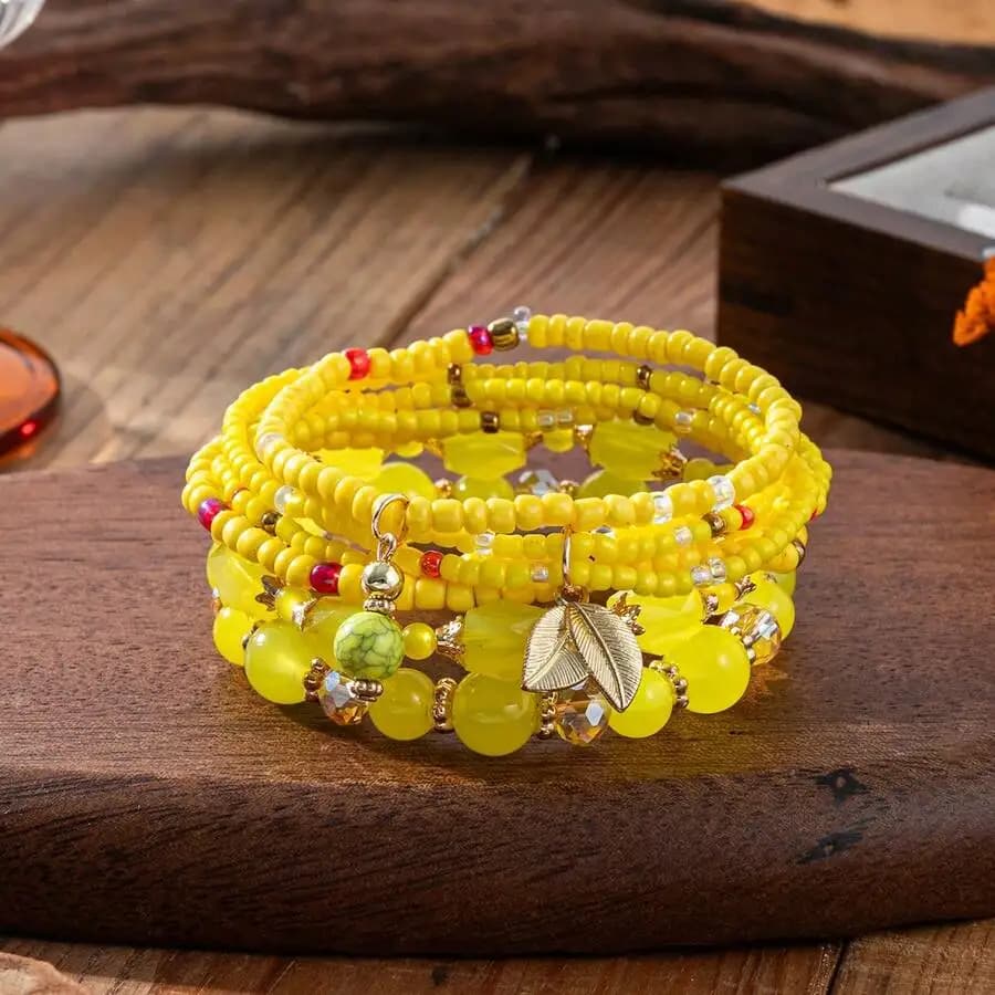 Set di 4 braccialetti avvolgenti con perline gialle, ciondolo a foglia d'oro e accenti di pietre preziose miste