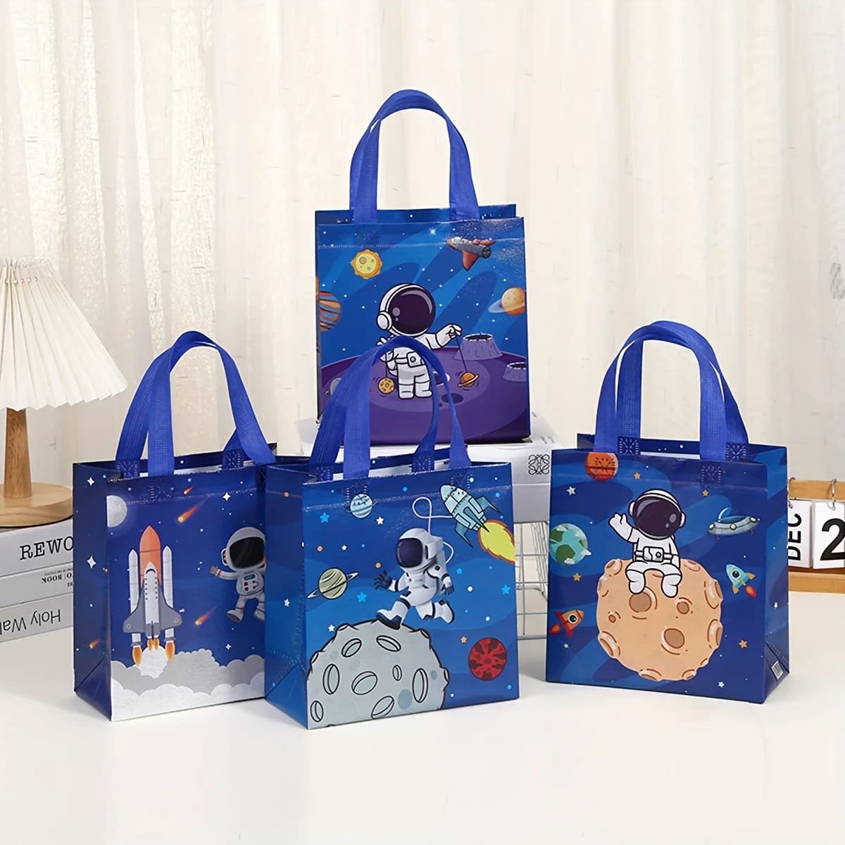 Confezione da 12 sacchetti regalo in tessuto non tessuto con motivo astronauta e manici. Dimensioni: 9,06 x 8,66 x 4,33 pollici