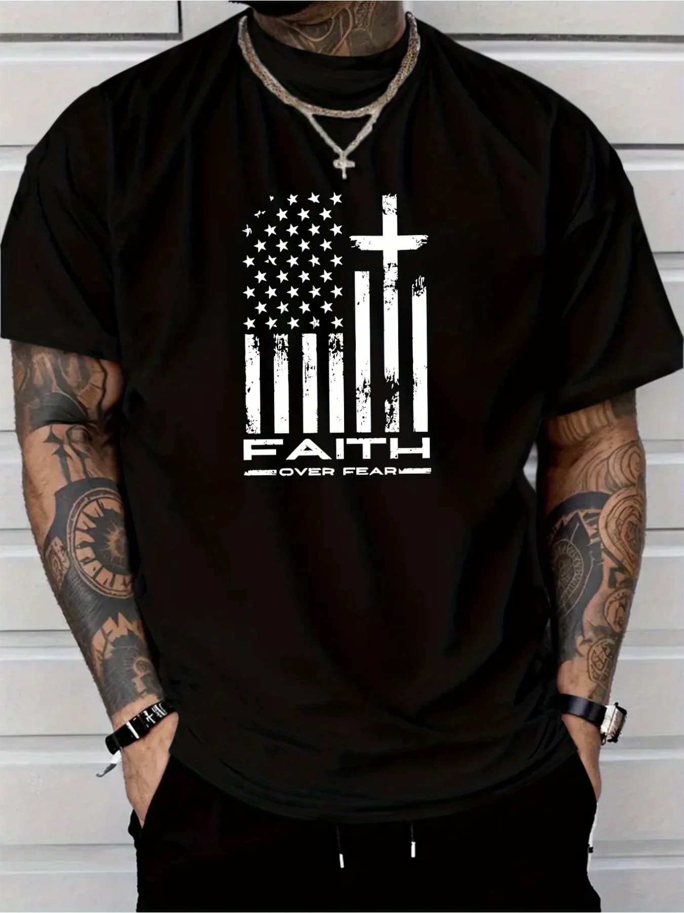 Black T-Shirt to Maniche Court for Man | Unique graphics with American flag and cross with text “FAITH” and “OVER FEAR”, urban style, comfortable.
