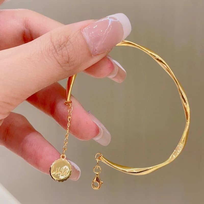 Bracciale Mobius color oro con catena elastica aperta, lusso discreto e sensazione di alta gamma, stile raffinato e versatile per fate.