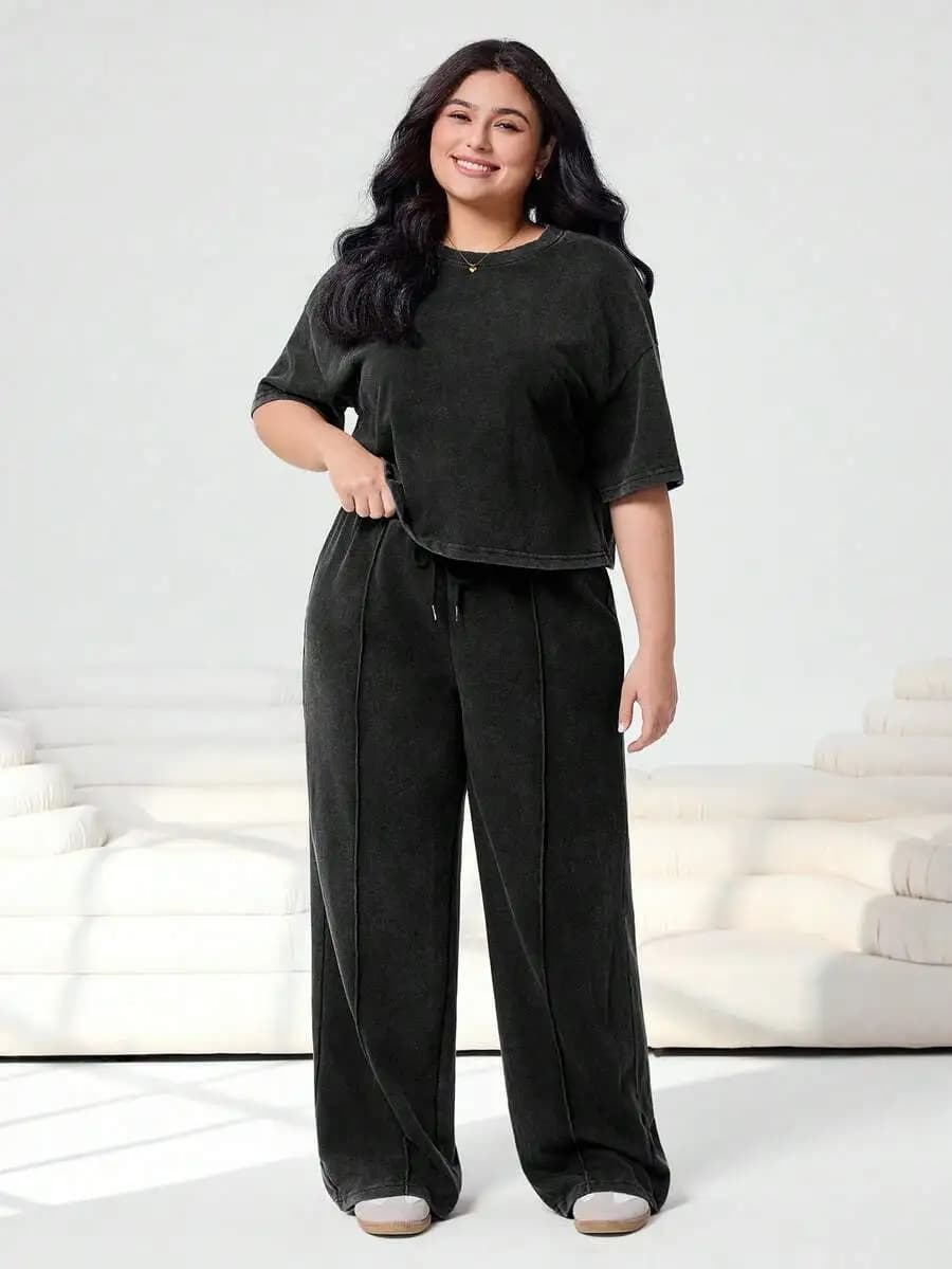 Completo casual due pezzi taglie forti: T-shirt cropped lavata nera macchiettata e pantaloni della tuta a gamba larga