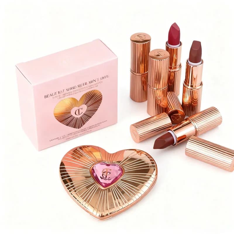 Fard in polvere bicolore a forma di cuore, rosa pesca, piccolo tubo d'oro, rossetto, cuscino Talk Star, stessa marca, trucco Charlotte Tilbury