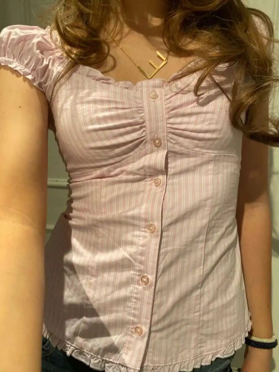 Camicetta da donna rosa a righe con bottoni, maniche a volant e scollo a V