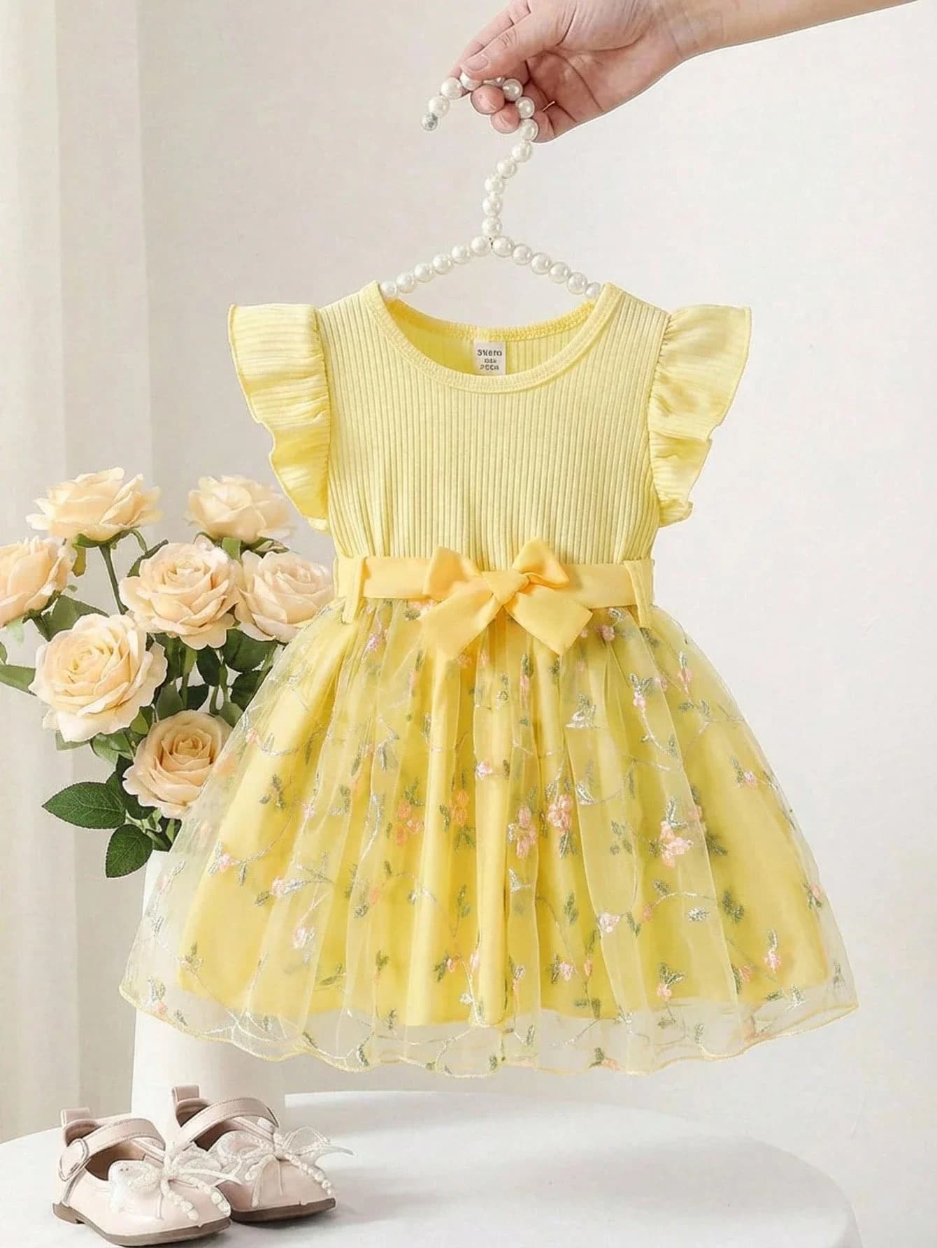 Elegante abito in rete ricamata giallo chiaro con maniche a volant in maglia a coste e cintura con fiocco in vita
