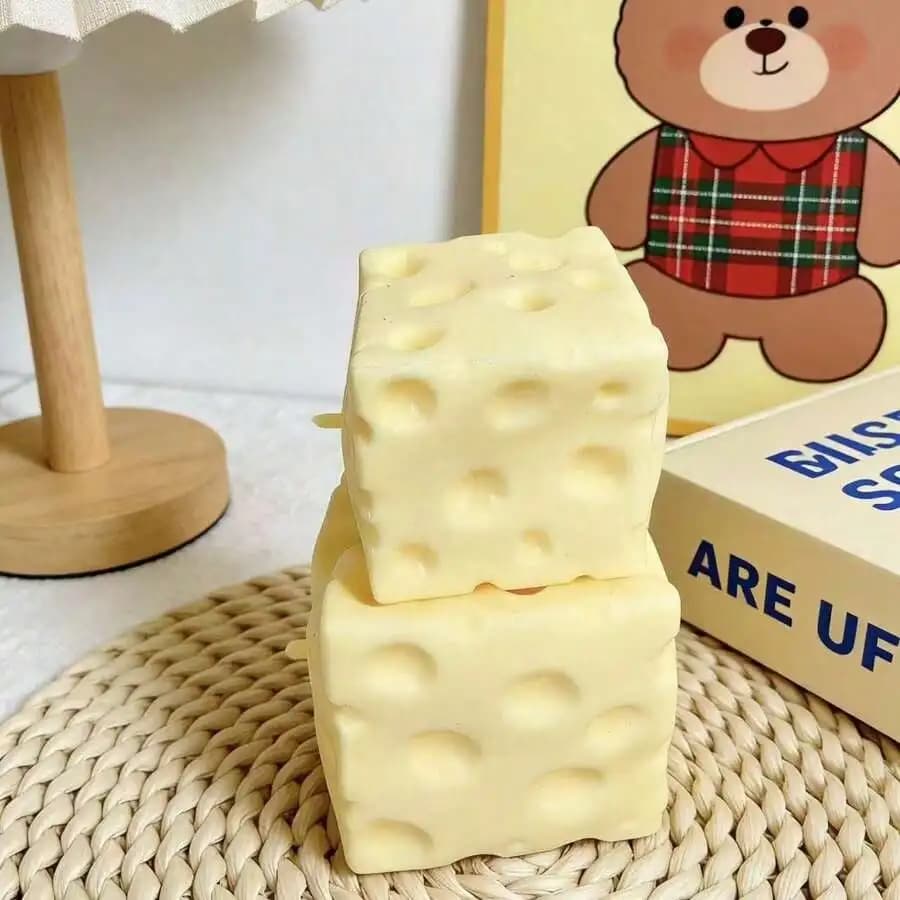 Giocattolo morbido a forma di formaggio giallo pallido con ripieno di crema al cocco, realizzato in pasta morbida. Design silenzioso e comprimibile per alleviare lo stress