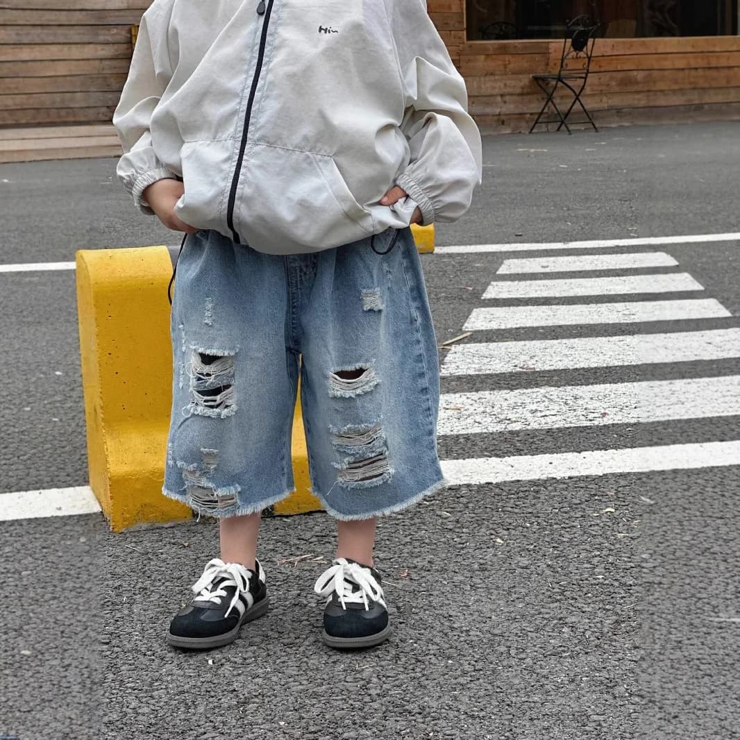 2025 Nuovi pantaloncini di jeans da ragazzo estivi con fori Versione coreana alla moda Pantaloni cinque quarti alla moda e belli