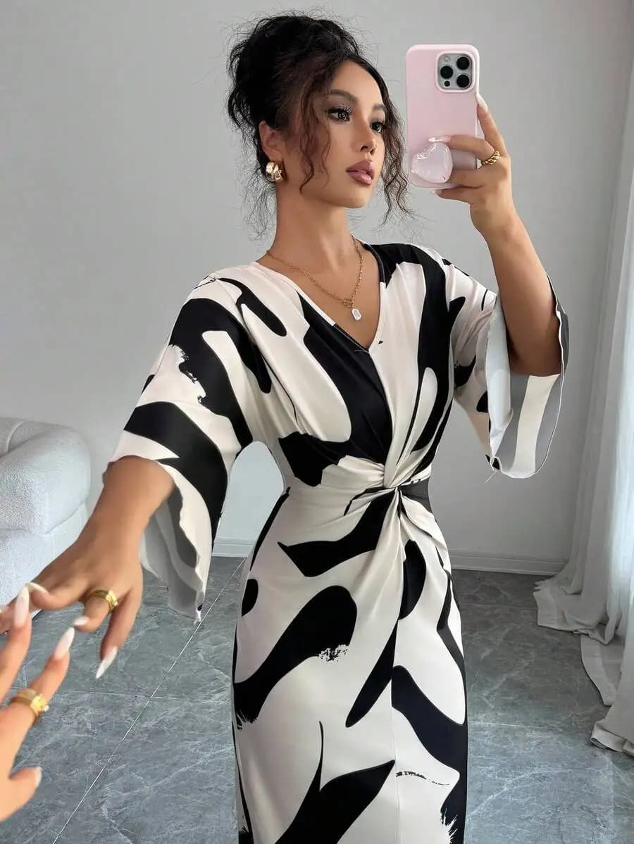Abito midi con stampa astratta in bianco e nero, scollo a V, vita attorcigliata e maniche a campana