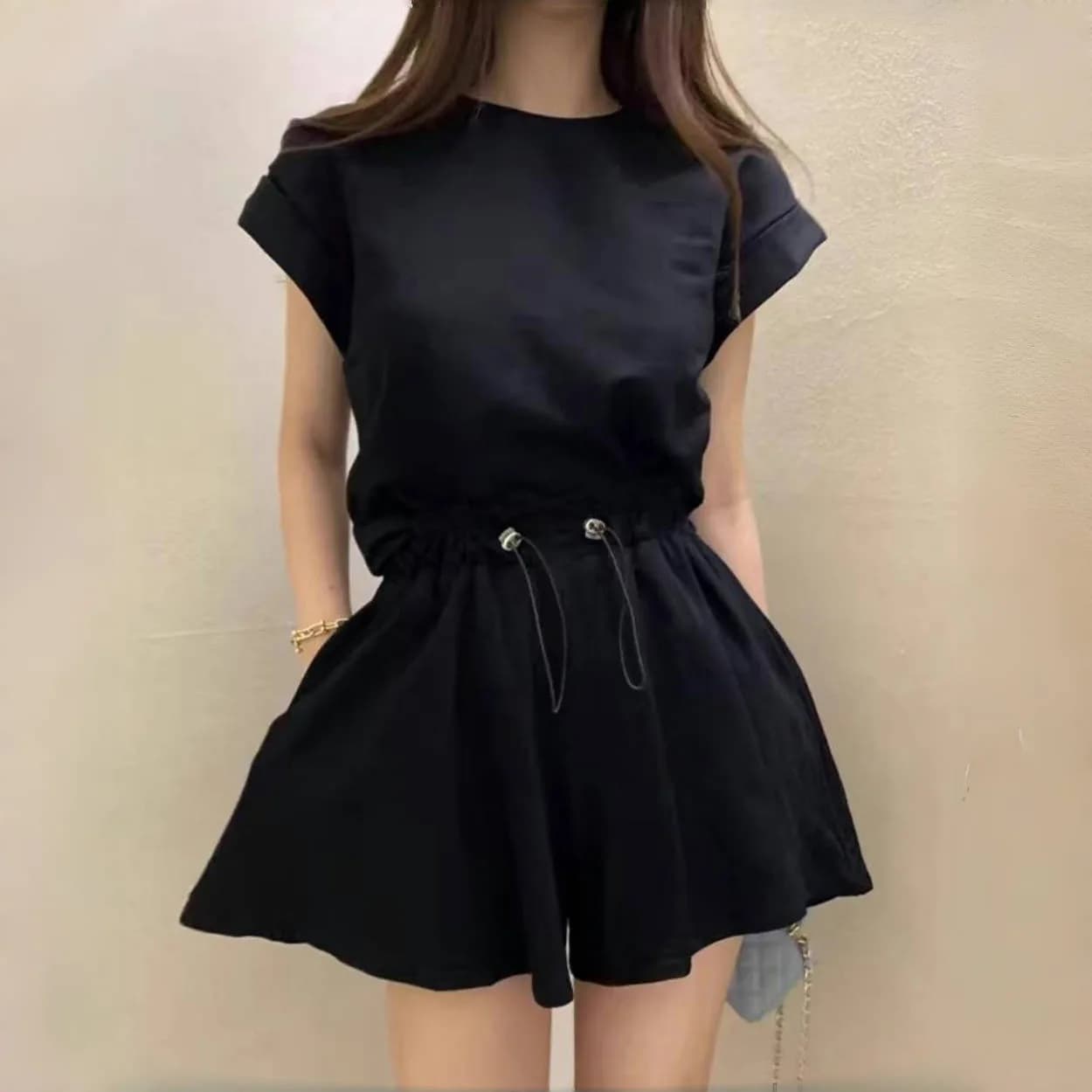 Elegante completo due pezzi da donna con t-shirt a maniche corte e pantaloncini a gamba larga con coulisse, per l'estate, moda casual e sportiva.