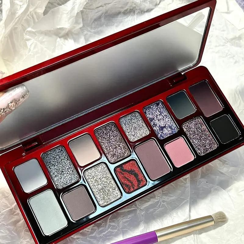 A small palette of black and red gothic shadows, a dark eyeliner, niche, super cool and elegant
