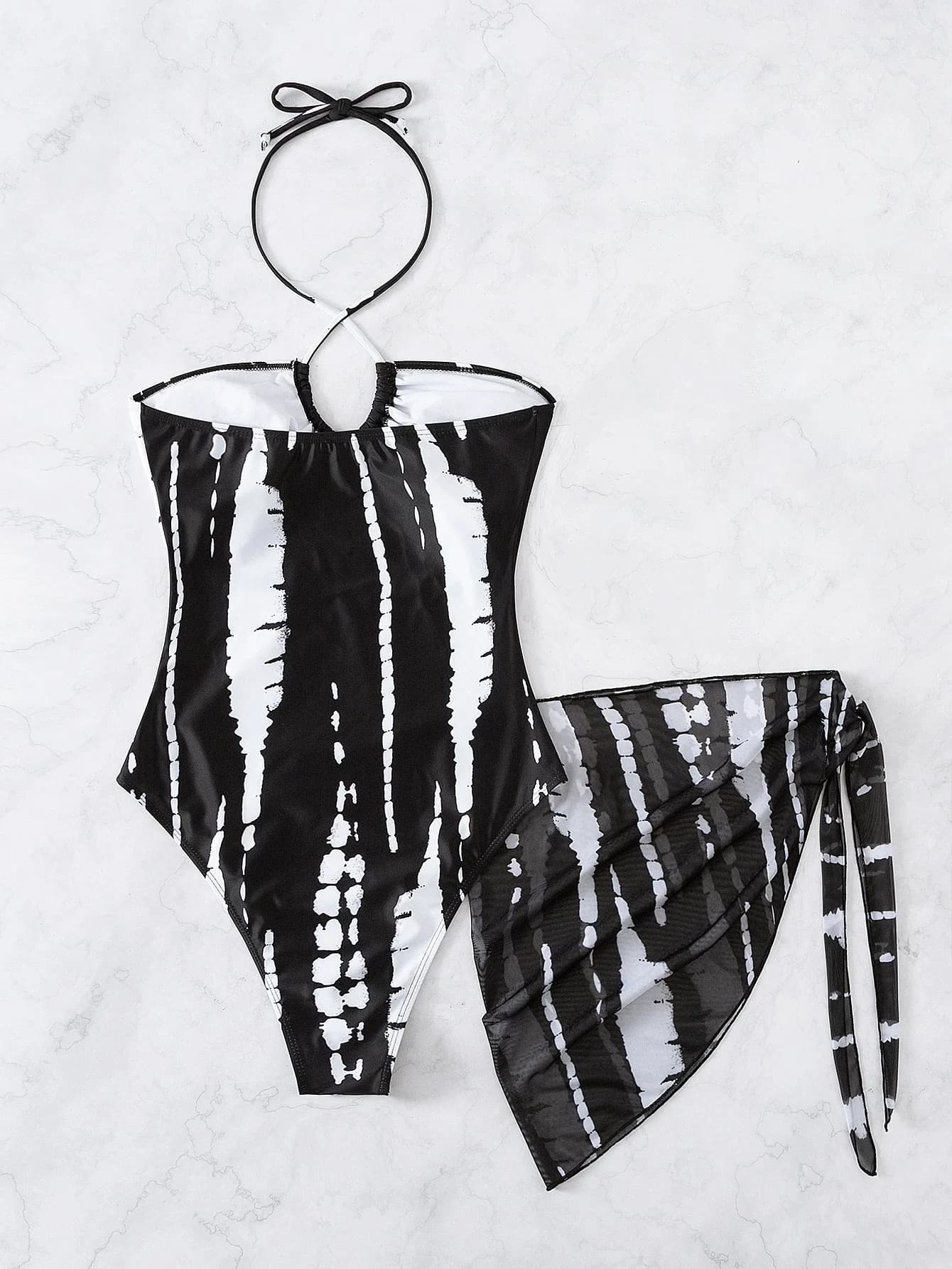 Costume intero bianco e nero con stampa tie-dye, scollo all'americana, dettagli cut-out e gonna a balze trasparente