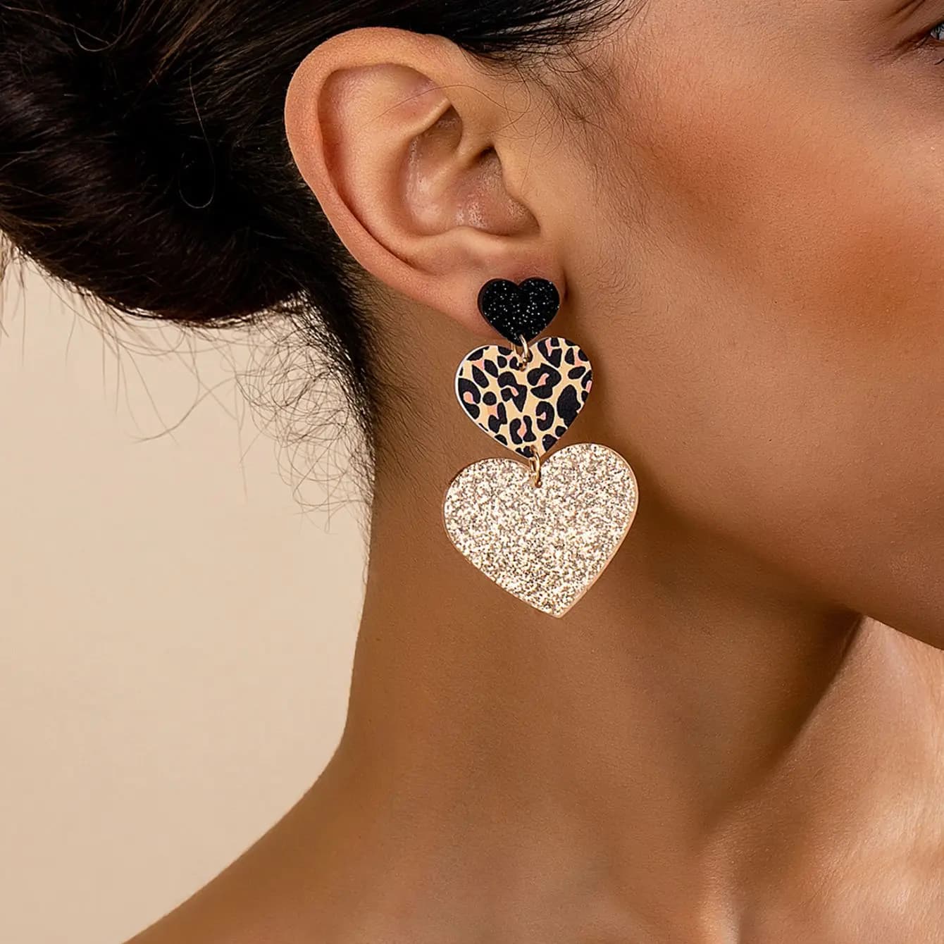 Un paio di orecchini pendenti da donna, orecchini stile discoteca in acrilico a forma di cuore con stampa leopardata esagerata