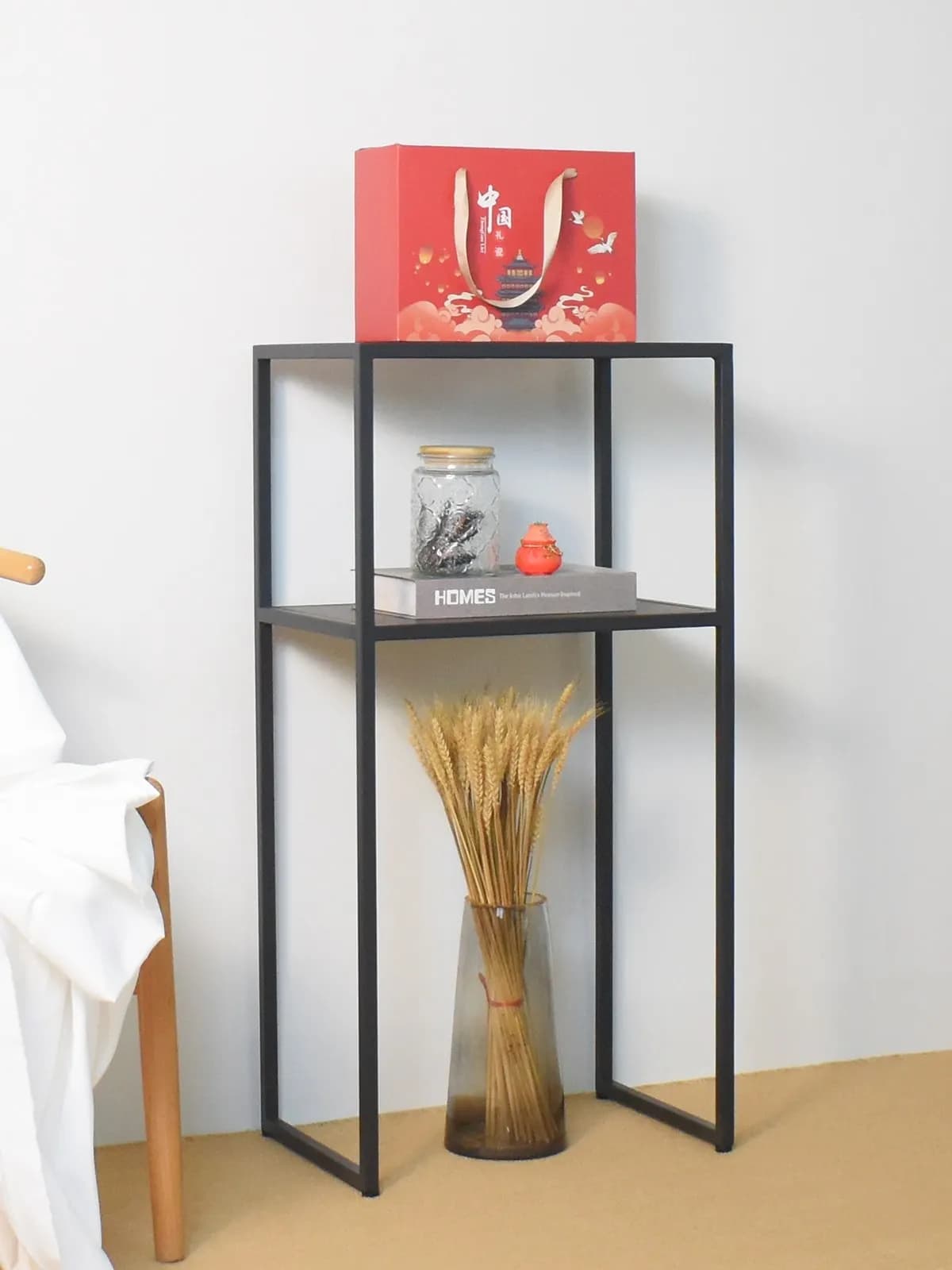 Divano nordico da soggiorno con pochi accessori: semplice porta fiori, dispenser d'acqua, cestino, porta robot aspirapolvere, doppio ripiano portaoggetti