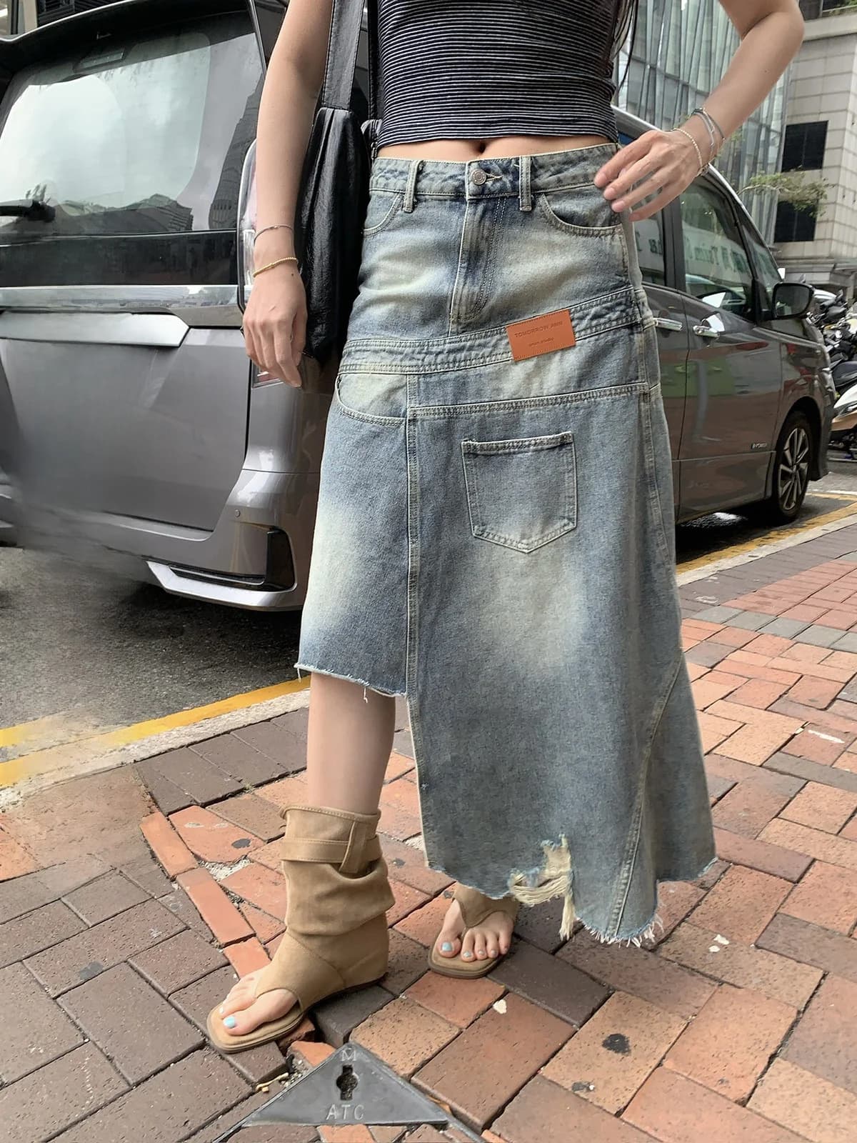 Gonna in denim a vita alta con orlo asimmetrico e bordi sfrangiati, design che nasconde le fianchi, di Sinbounboun per donna, Primavera 2026