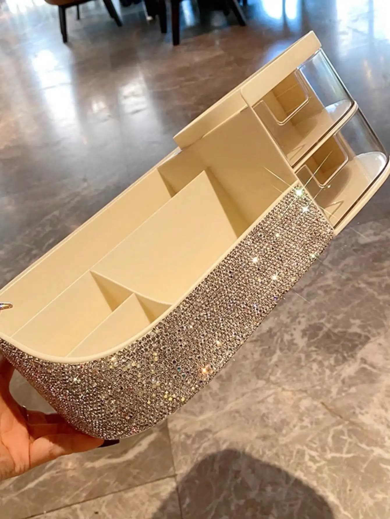 Un pennello per trucco artificiale tempestato di diamanti e una scatola portaoggetti in stile cassetto per prodotti per la cura della pelle
