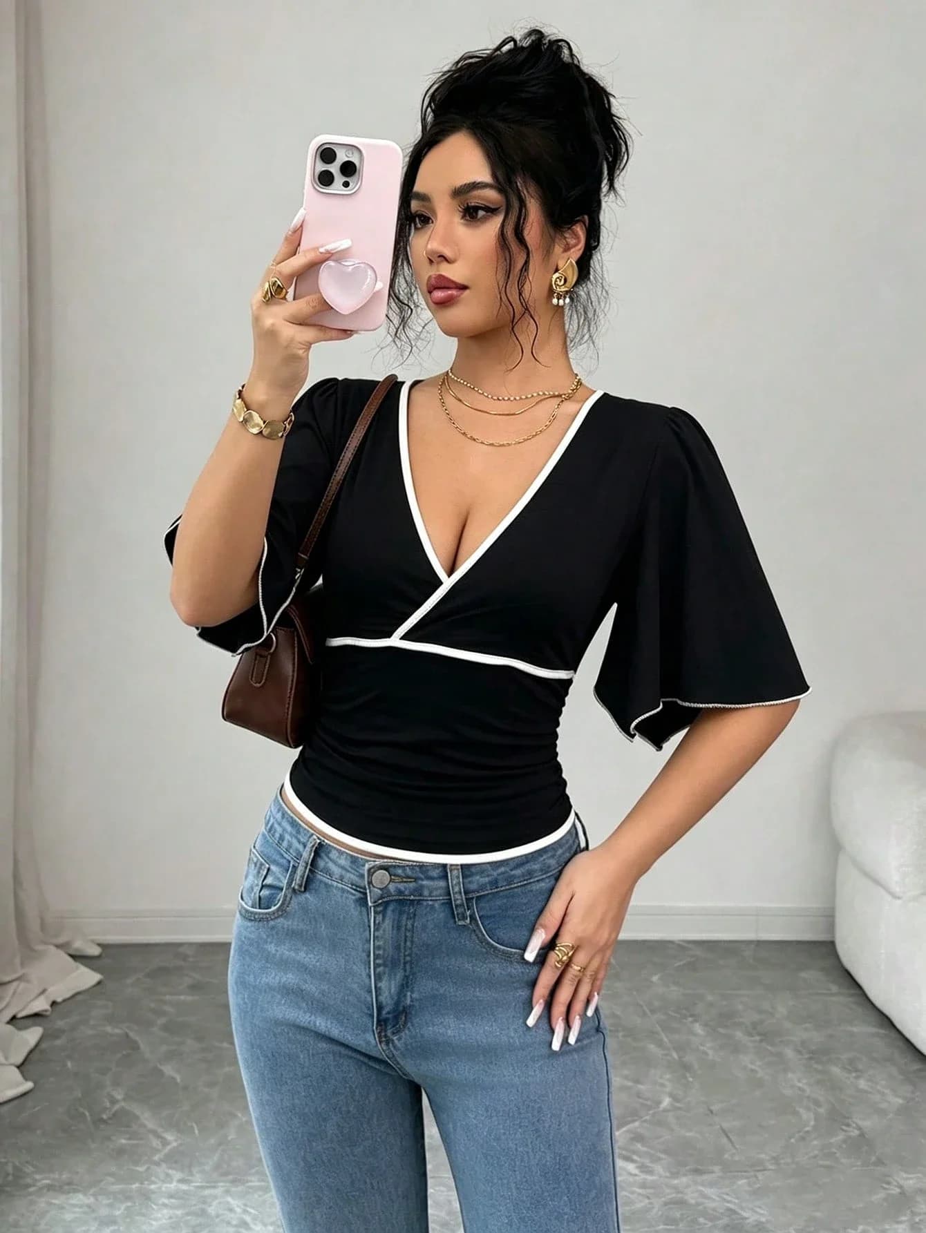 Elegant and versatile women's solid color T-shirt with contrasting trim, V-neck, and ruffled sleeves.