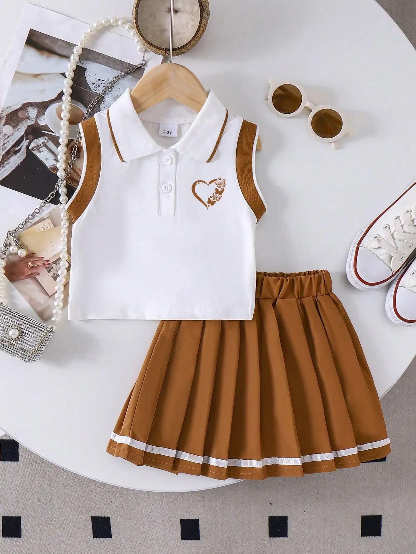 Completo estivo da donna con top polo senza maniche e gonna a pieghe, stile scolastico con ricamo a cuore.