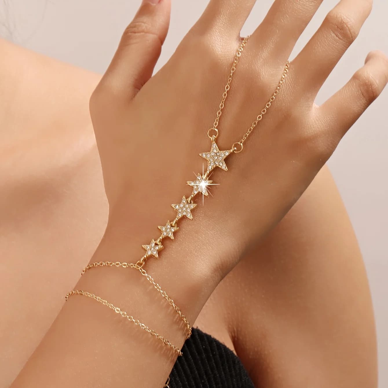 Un braccialetto da donna alla moda ed elegante con catena a stella scintillante che si avvolge intorno al dito, adatto per appuntamenti quotidiani